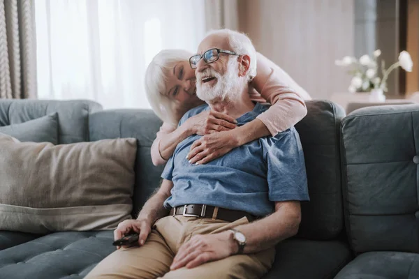 Feliz anciano casado pareja abrazando en sofá — Foto de Stock
