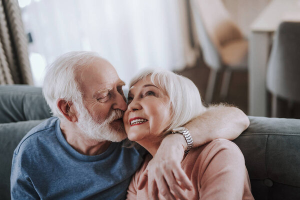 Positive elder couple feeling love to each other