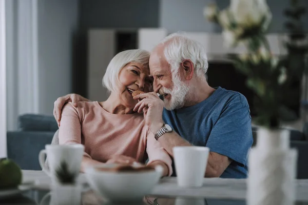 Positive ældre par drikker te med cookies - Stock-foto