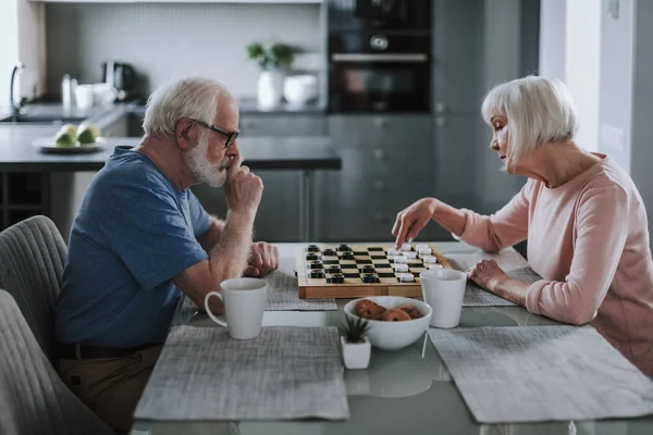 Yaşlı emekli çift evde çek oynuyor — Stok fotoğraf