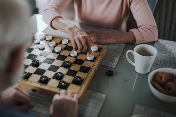 Äldste man och kvinna spelar kontroller tillsammans — Stockfoto