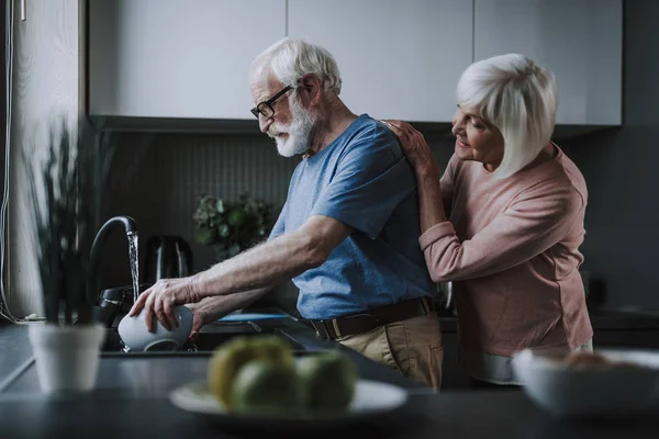 Glückliches Seniorenpaar spült Geschirr in der Küche — Stockfoto