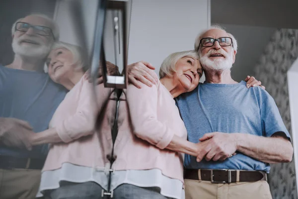 Feliz pareja de ancianos abrazándose juntos en la cocina —  Fotos de Stock