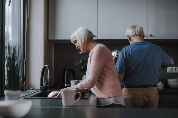 Pareja mayor disfrutando de hacer tareas domésticas — Foto de Stock