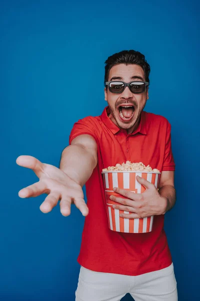 Талія Кавказький емоційний чоловік тримає попкорн відро на синьому тлі — стокове фото