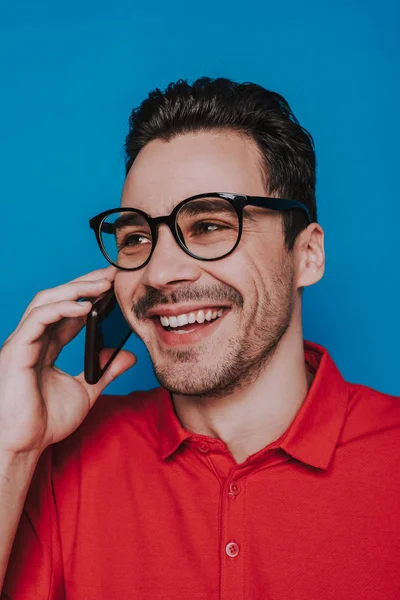 Låg vinkel porträtt av lycklig man pratar på smartphone i studion — Stockfoto