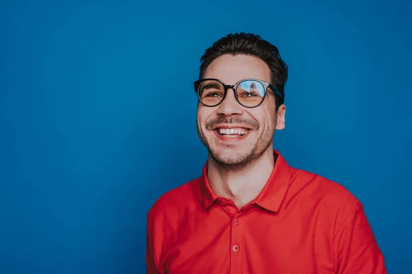 Μισό μήκος του όμορφος χαμογελαστός τύπος με γυαλιά που βρίσκονται σε μπλε φόντο — Φωτογραφία Αρχείου