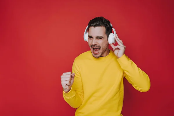 Cintura para arriba de chico joven gritando mientras escucha música en el estudio —  Fotos de Stock