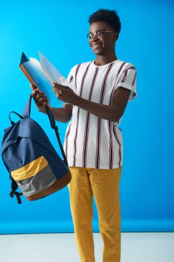 Genç Afro öğrenci bakıyor at dosyalar içinde onun eller