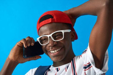 Gülümseyen Afro Amerikan öğrenci telefonla sohbet