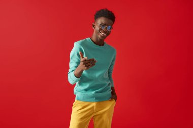 Pozitif Afro Amerikan adam kırmızı arka planda duruyor