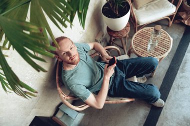 Neşeli adam kafede akıllı telefon kullanıyor