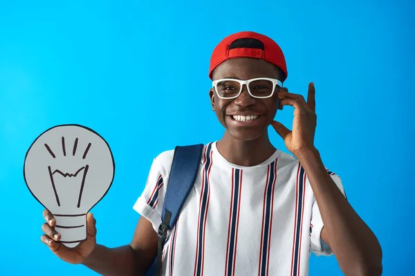 Glimlachende Afro Amerikaanse student poseren met kartonnen gloeilamp — Stockfoto