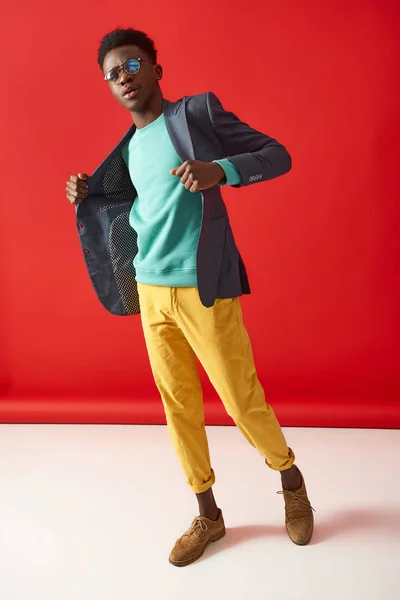 Guapo afroamericano chico está posando sobre rojo fondo — Foto de Stock