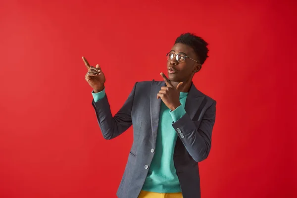 Positieve Afro Amerikaanse man poseert op rode achtergrond — Stockfoto