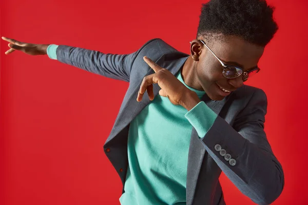 Hombre afro americano alegre en gafas bailando sobre fondo rojo — Foto de Stock