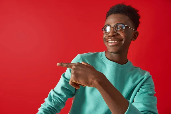 De gelukkige Afro Amerikaanse kerel poseert op rode achtergrond — Stockfoto