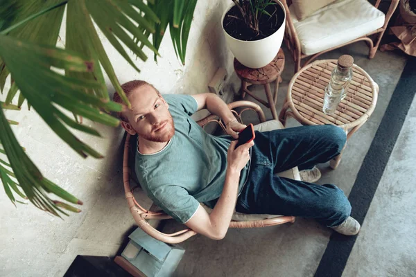 Neşeli adam kafede akıllı telefon kullanıyor