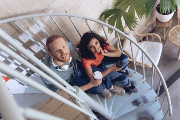 Szczęśliwy facet jest relaksujący z dziewczyną na klatce schodowej z kawą — Zdjęcie stockowe