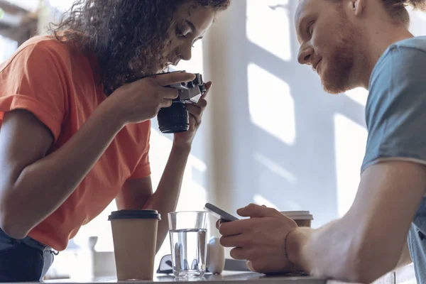 Fiatal házaspár használja kamera és telefon a kávézóban — Stock Fotó