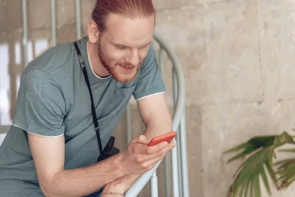 Gladlynt kille med Vintage kamera och smart telefon inomhus — Stockfoto