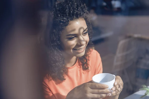 Весела молода жінка розслабляється з чашкою кави — стокове фото
