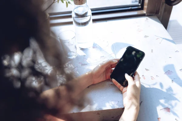 Vrouw is met behulp van slimme telefoon in café — Stockfoto