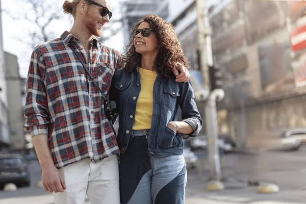 Vrolijke jonge mensen zijn knuffelen tijdens de wandeling buitenshuis — Stockfoto