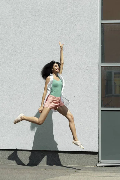 魅力的なブルネットの女の子が空気中にジャンプし、手を上げる — ストック写真