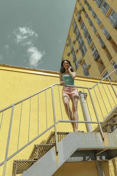 Sokakta merdivenlerde duran büyüleyici genç kadın