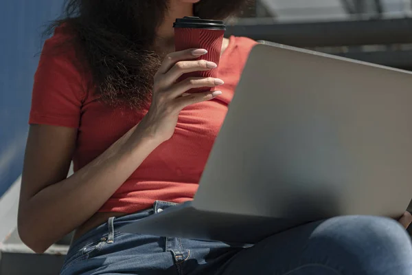 Νεαρή γυναίκα με φλιτζάνι καφέ χρησιμοποιώντας φορητό υπολογιστή — Φωτογραφία Αρχείου
