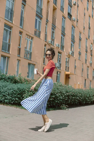 Belle jeune femme avec boisson à emporter debout dans la rue — Photo