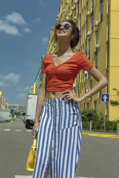 Attraente giovane donna in occhiali da sole in piedi sulla strada — Foto Stock