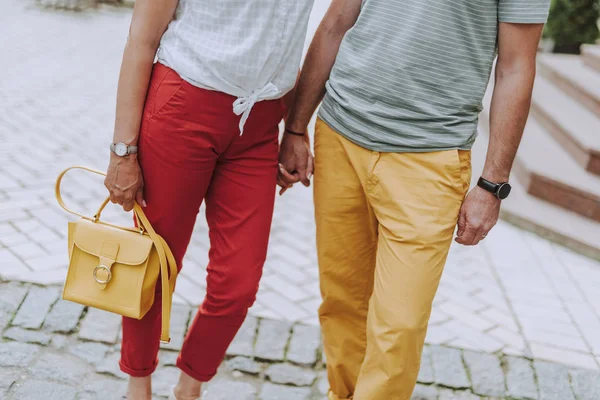 Adult man and woman holding hands outdoors — Stock Photo, Image