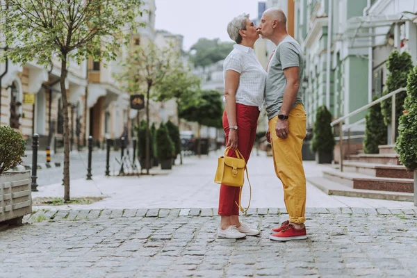 Glückliches grauhaariges Paar, das die Straße entlang geht — Stockfoto