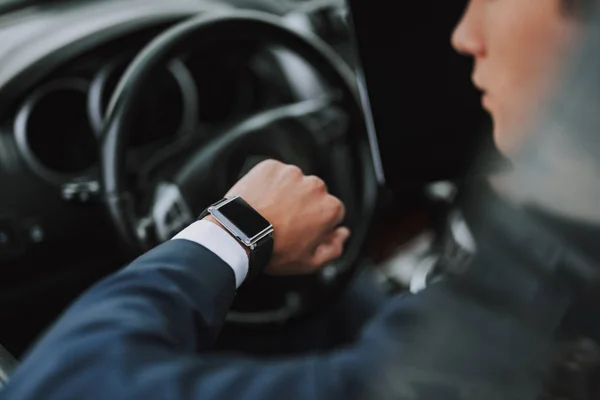 Hombre sentado en su auto y mirando su reloj —  Fotos de Stock