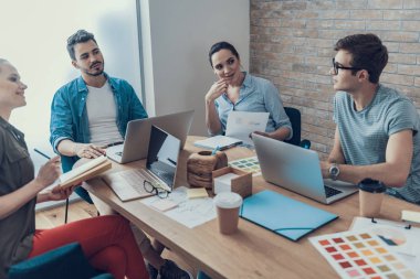 Start-up ekibi çalışma odasında iş fikirleri hakkında konuşuyor