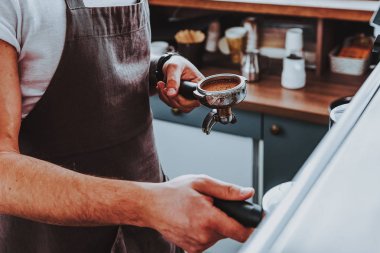Önlük takan baristanın yakın çekim filtresi tutucu