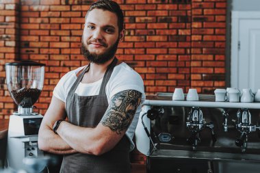 Kollarını çapraz ve gülümseyerek ayakta neşeli barista Bel kadar