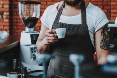 Ayakta ve espresso tutan sakallı barista yakın