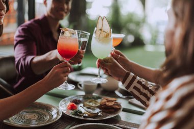 Arkadaşlar kafede vakit geçirirken kokteyllerle tost