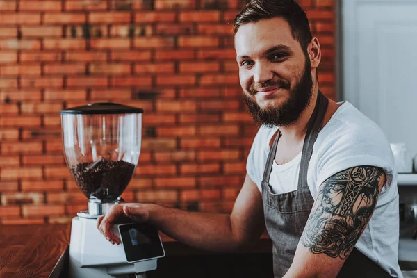Primer plano de barista positivo poniendo una mano en el molinillo de café — Foto de Stock
