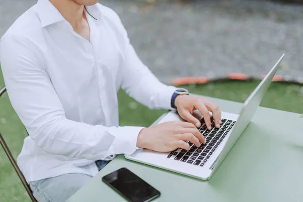 Jovem de camisa clássica branca usando notebook moderno — Fotografia de Stock