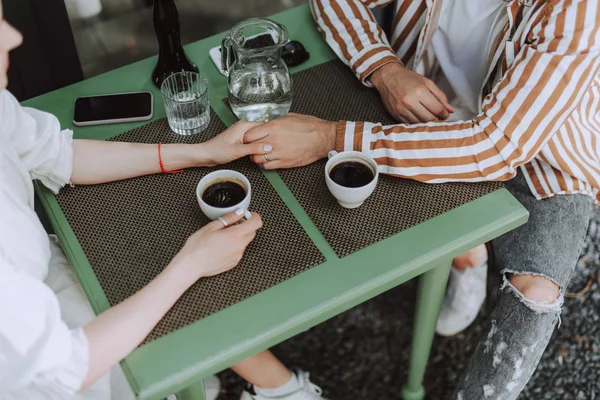 Par i kärlek hålla händerna i kaféet — Stockfoto