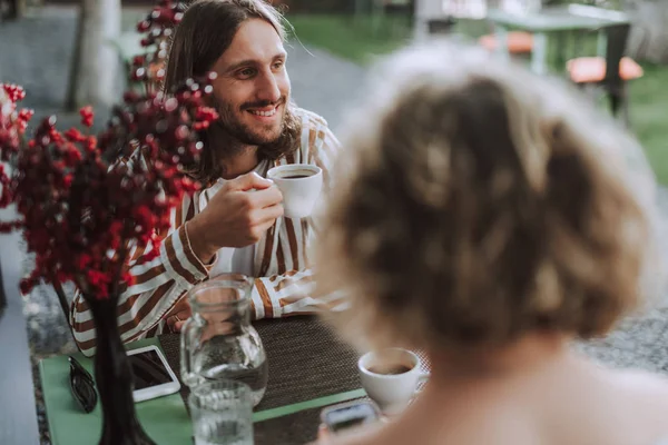 Fröhlicher junger Mann genießt Kaffee im Café im Freien — Stockfoto