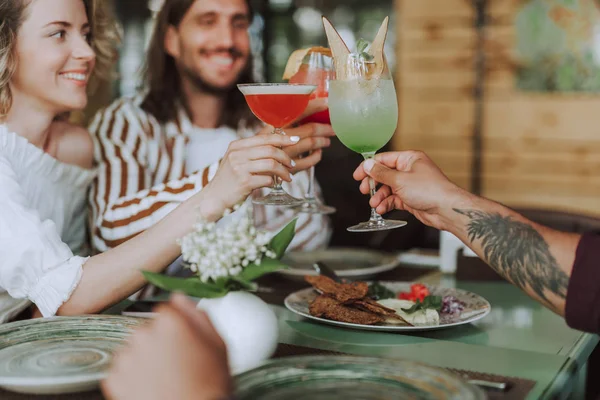 Tres amigos brindando con cócteles mientras pasan tiempo en la cafetería —  Fotos de Stock