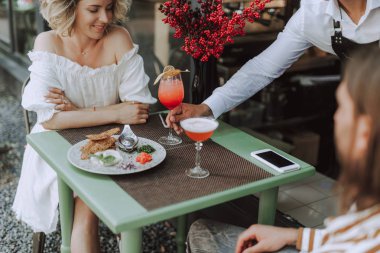 Barman açık hava kafede ziyaretçilere kokteyl hizmet
