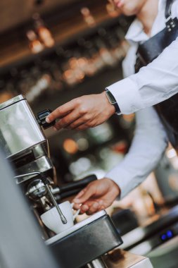 Barista taze espresso yapmak için profesyonel kahve makinesi kullanarak