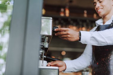 Yakışıklı barista taze espresso yapmak için profesyonel kahve makinesi kullanarak