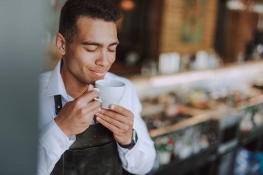 Kahve aromasının tadını çıkaran yakışıklı genç adam